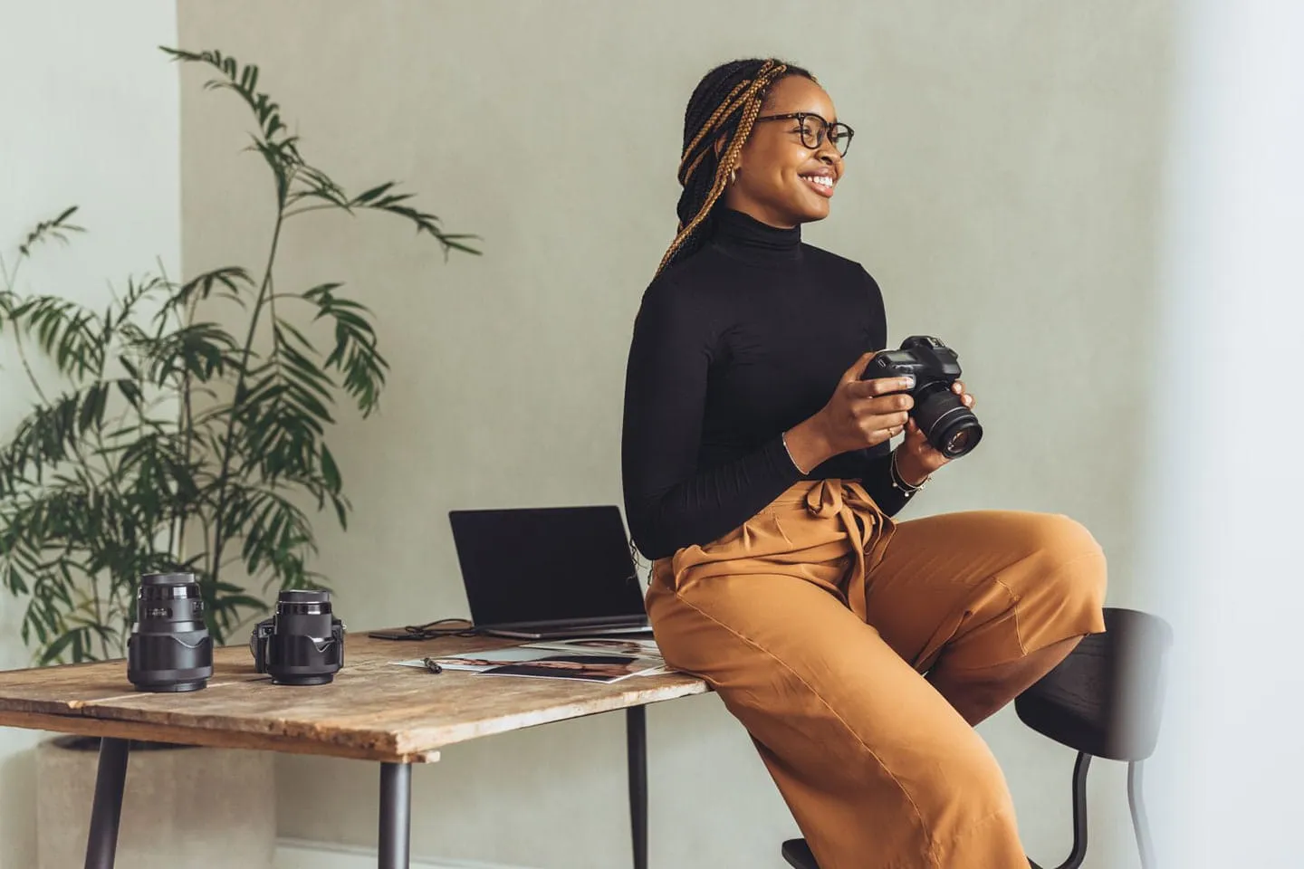 Professional female photographer holding a camera in natural lighting